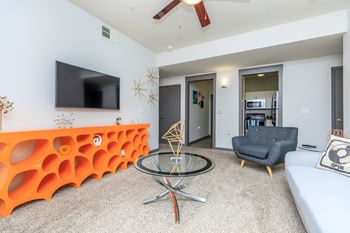 A living room with a television, a chair, and a table.